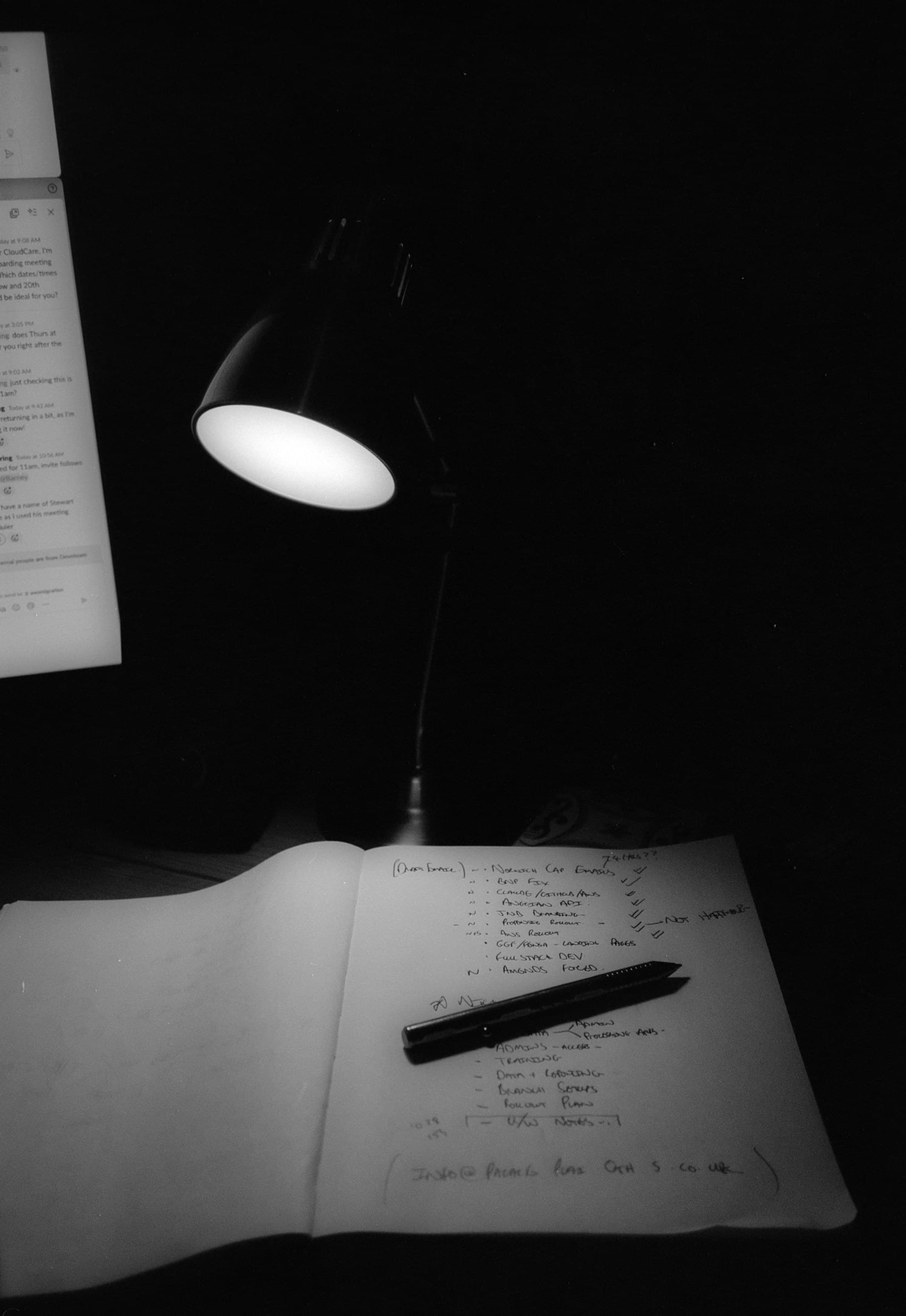 A lit desk lamp over an open journal