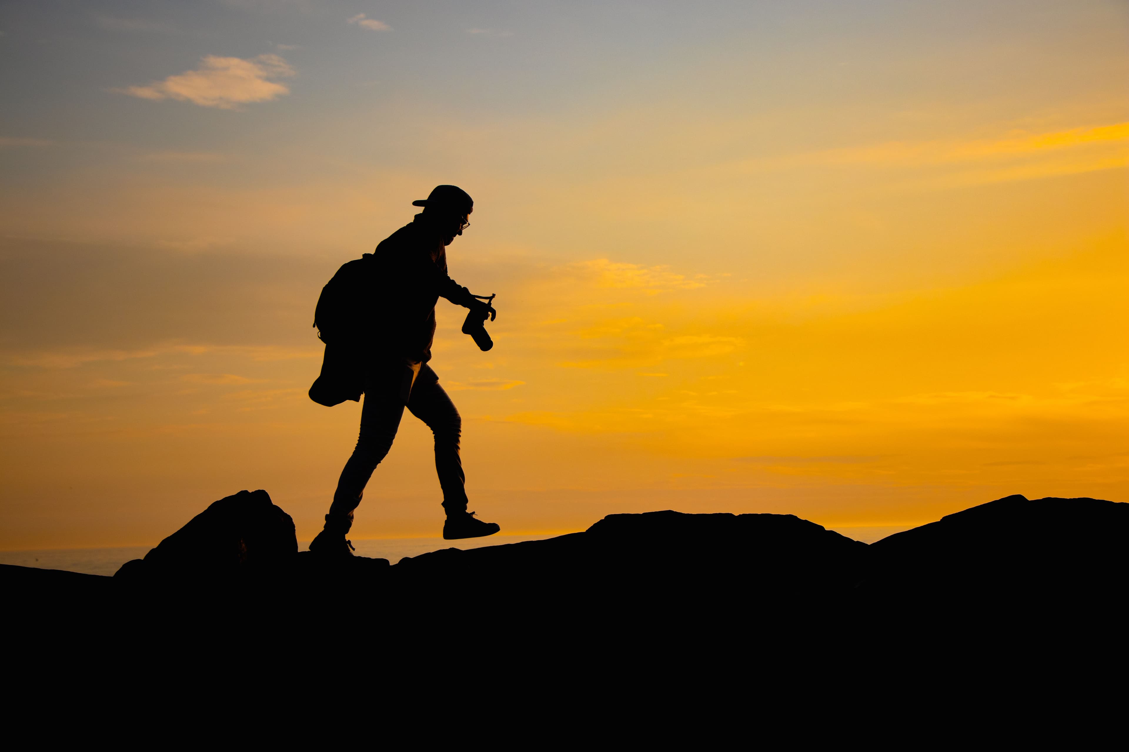 A lone hiker silhouetted against a sunset